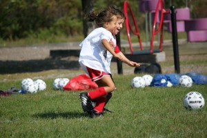 two young children fighting to kick a soccer ball