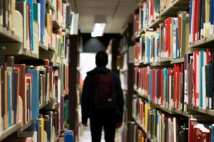 student walking through library aisle